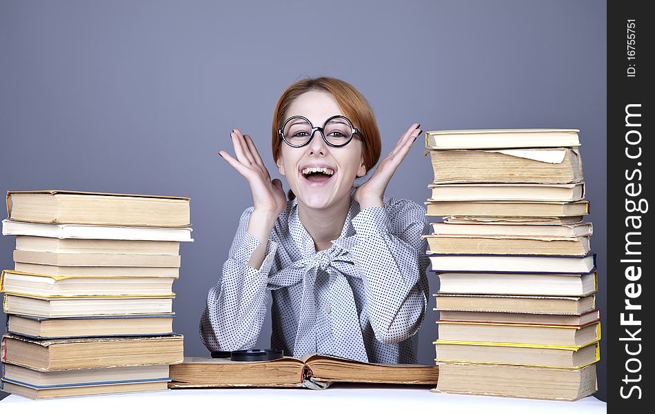 The young teacher in glasses with books. Studio shot.