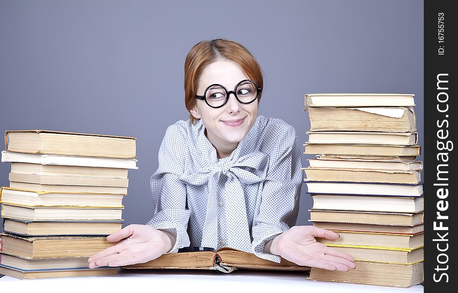 The young teacher in glasses with books.