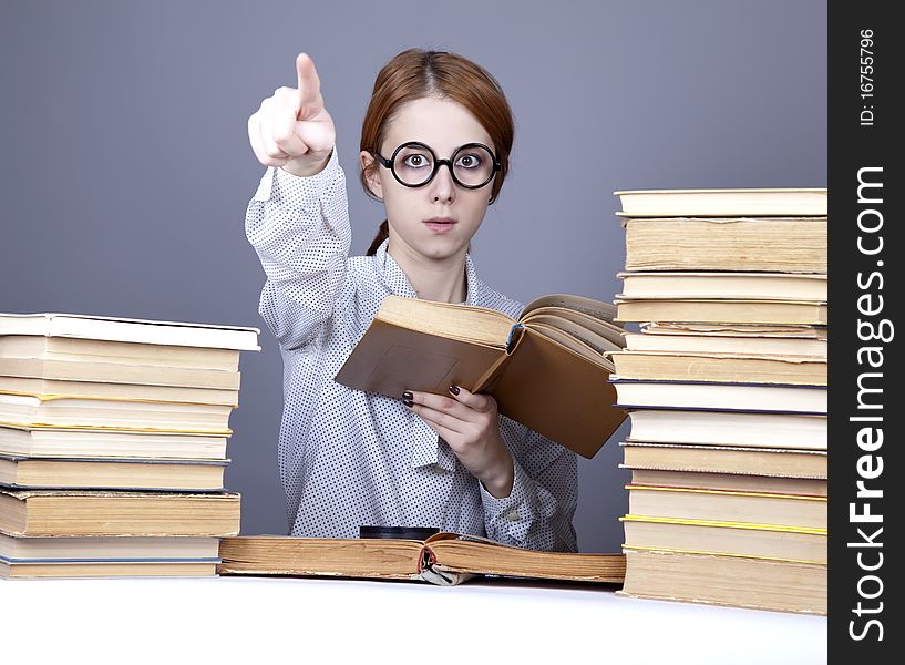 The young teacher in glasses with books.