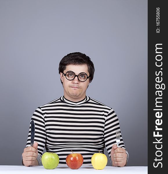 Funny boy try to eat apples. Studio shot.