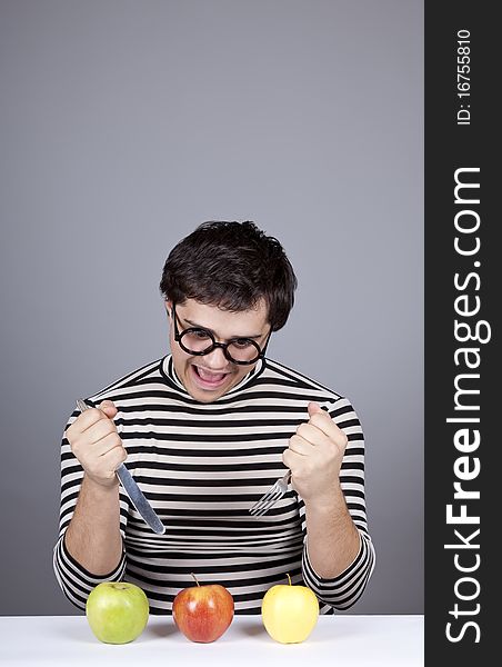 Funny boy try to eat apples. Studio shot.