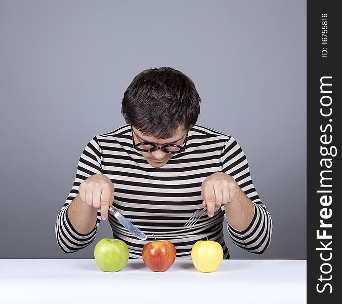 Funny boy try to eat apples. Studio shot.