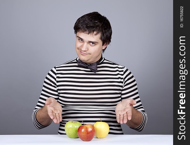 Funny boy try to eat apples. Studio shot.