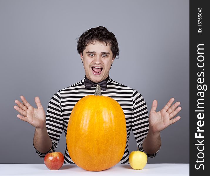 Funny men with two apples and one pumpkin. Studio shot.