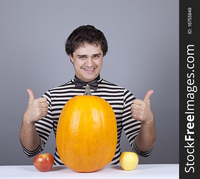 Funny men with two apples and one pumpkin. Studio shot.