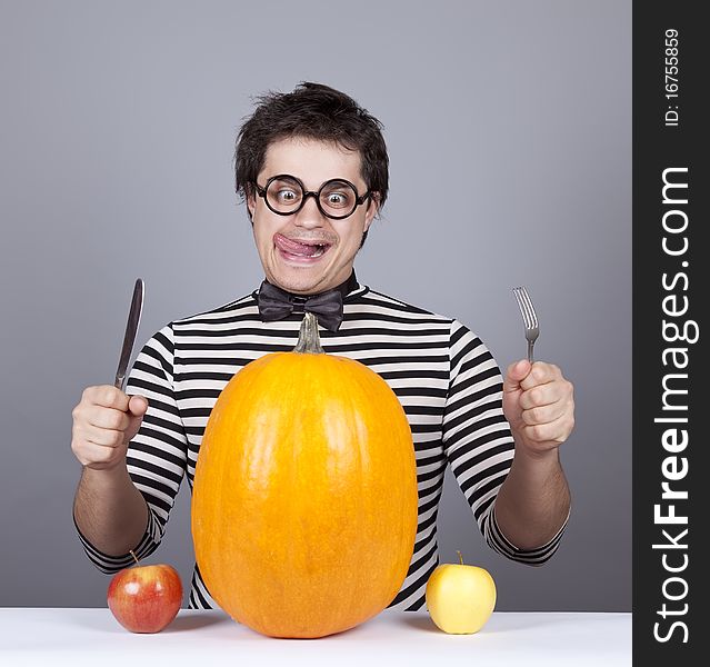 The young mad men try to eat apples and pumpkin.