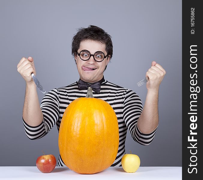 The young mad men try to eat apples and pumpkin.