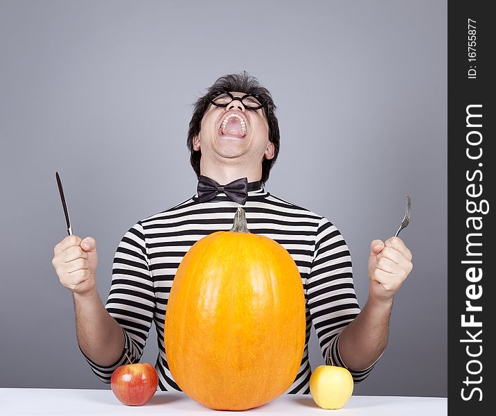 The young mad men try to eat apples and pumpkin.