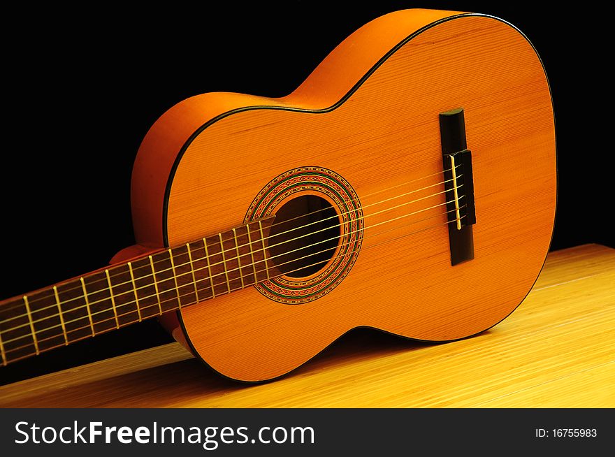 Classical acoustic guitar on the wooden floor