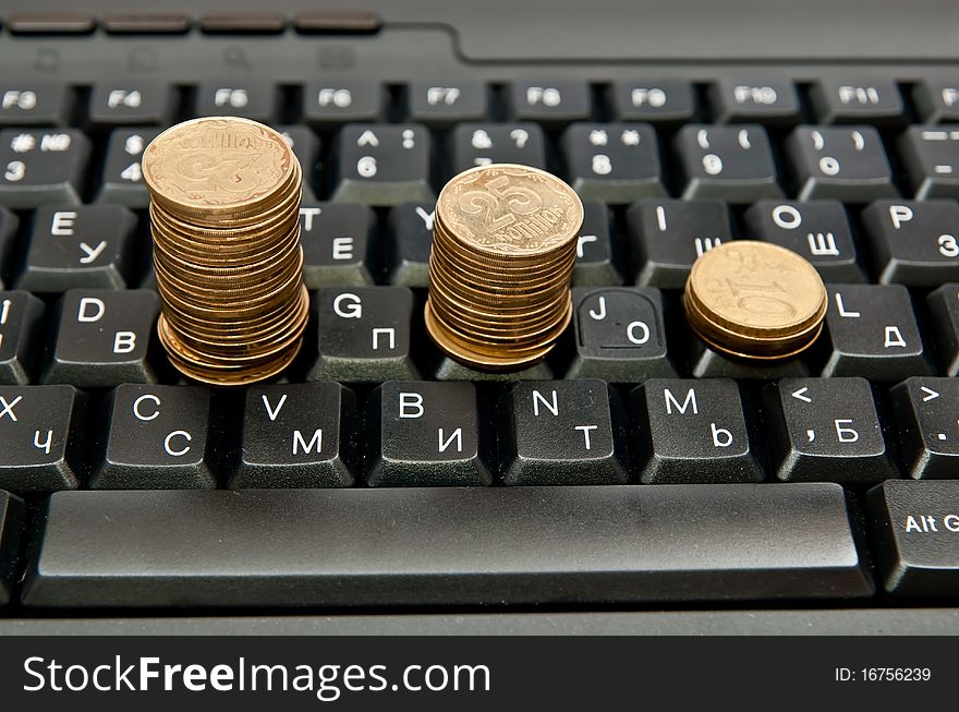 Stacks of coins on a black computer keyboard