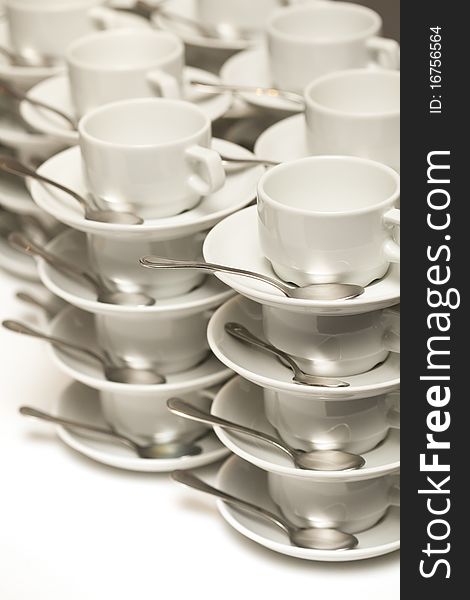 Stacked empty teacups with teaspoons