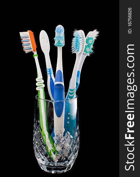 Toothbrush standing in a glass on a black background