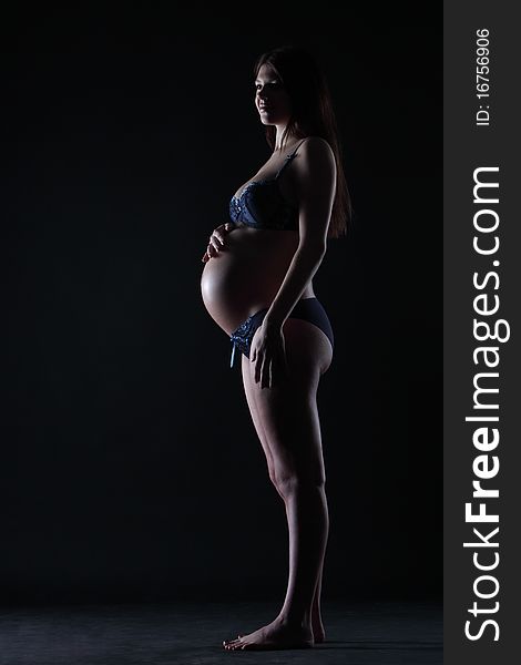 Silhouette of a pregnant woman in the darkness