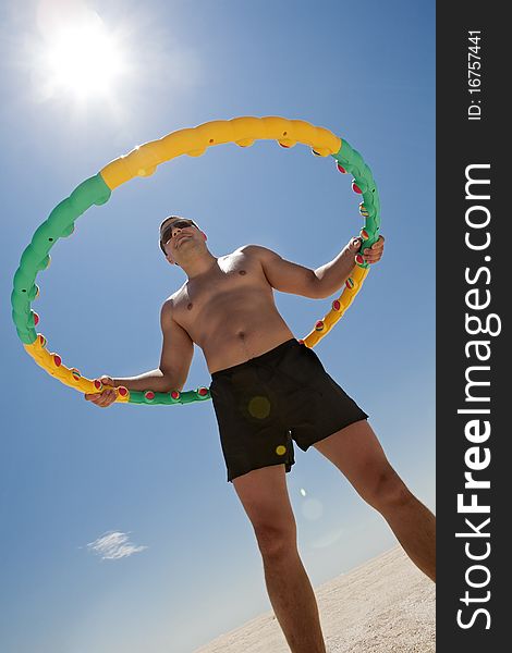 Young man Twirling Hula Hoop on the beach. Young man Twirling Hula Hoop on the beach