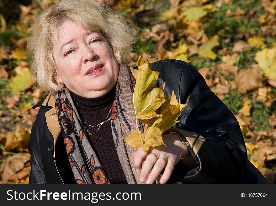 The beautiful woman with autumn leaves outdoor