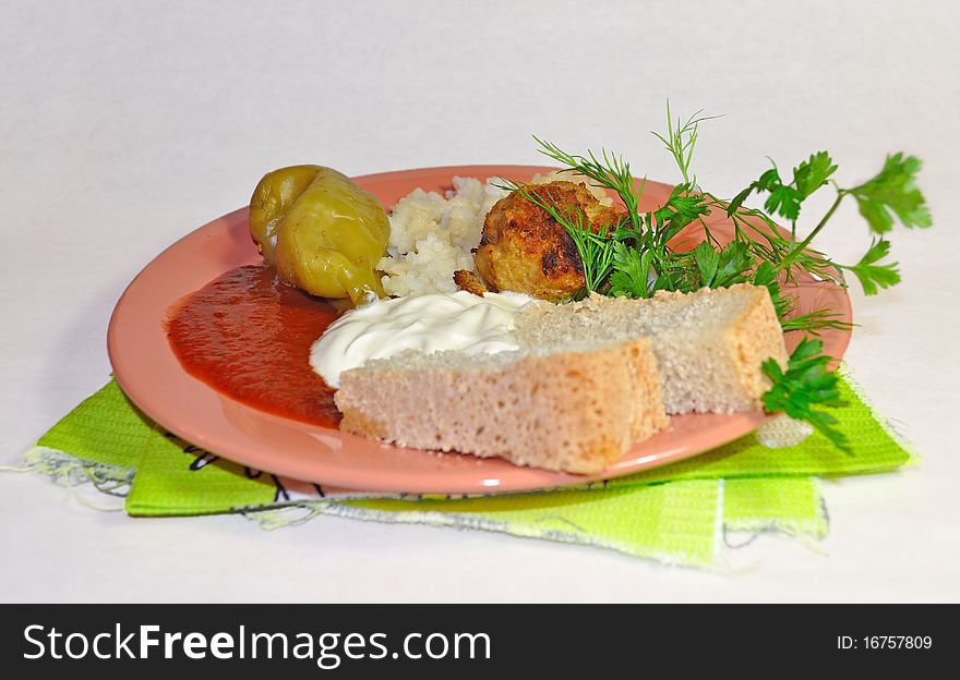 Russian supper with rice, stuffed pepper, meatballs, ketchup and mayonnaise