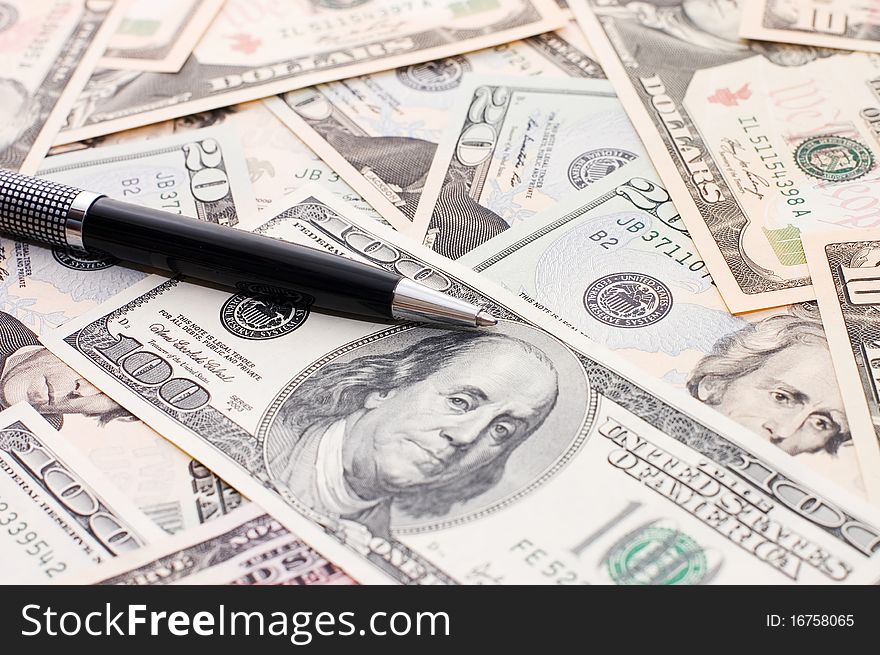 Dollar banknotes and pen close up