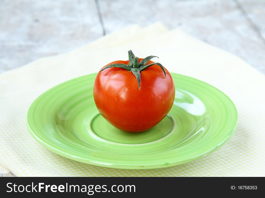 Beautiful tomato on a yellow napkin on the table