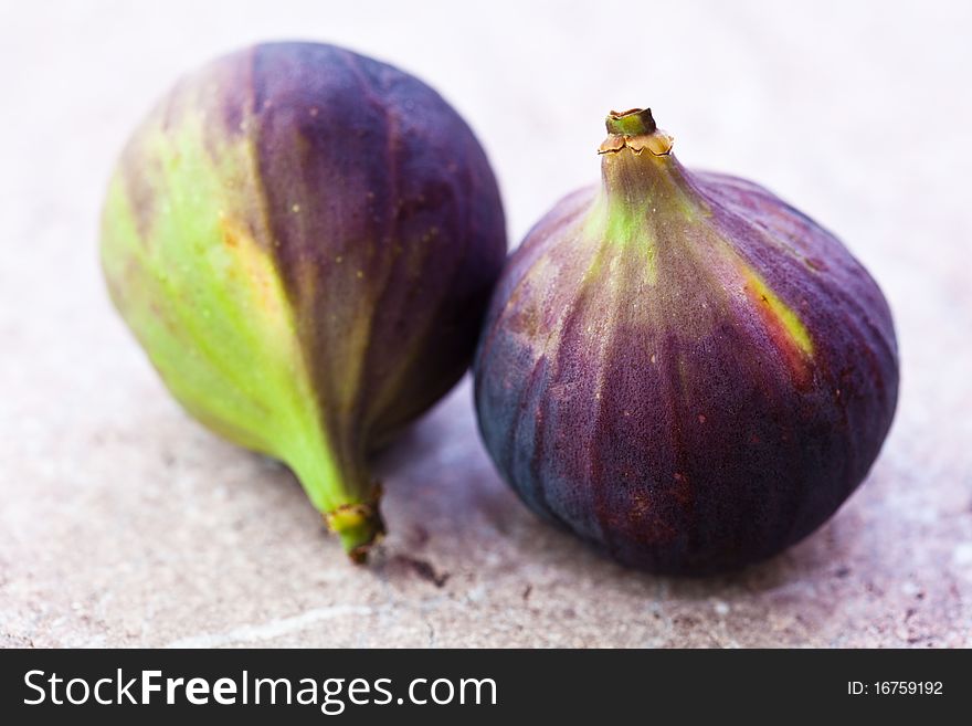 Closeup of two figs on a stone background