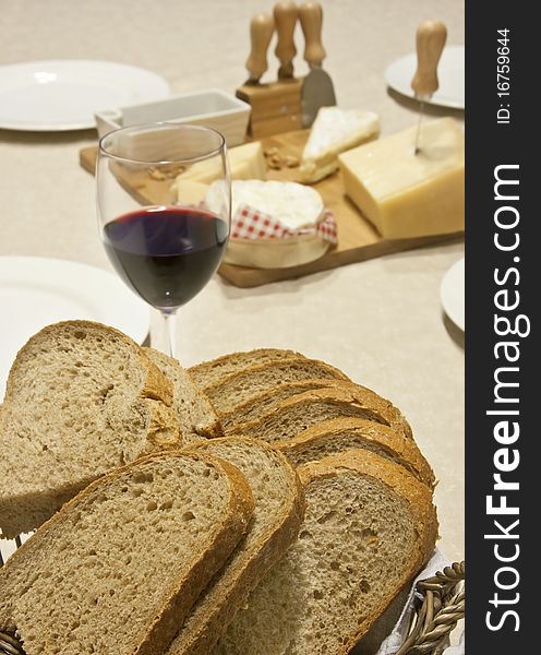 Slices of fresh bread with a glass of wine and cheese behind. Slices of fresh bread with a glass of wine and cheese behind