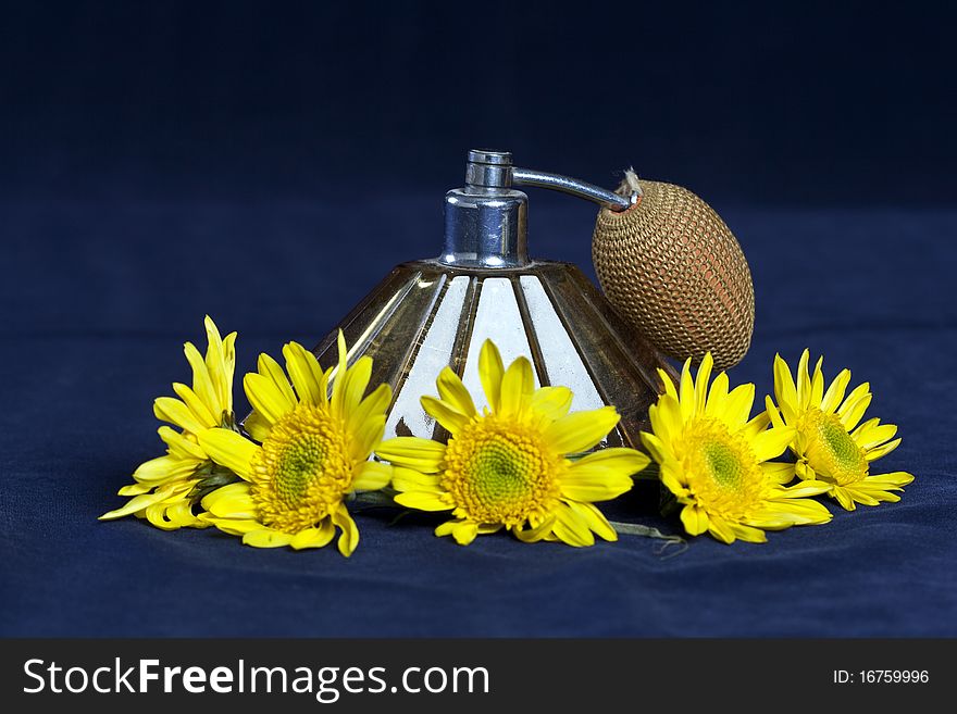 Arrangement of a perfume bottle sprayer and yellow flowers. Arrangement of a perfume bottle sprayer and yellow flowers