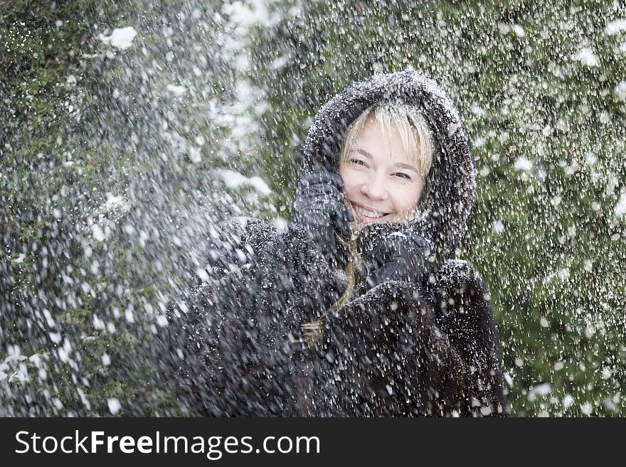 Woman in a fur hood covered with snow