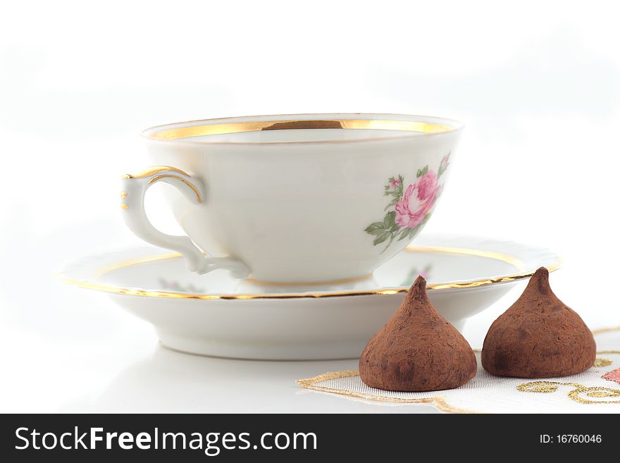 Tea cup and chocolates on a white background