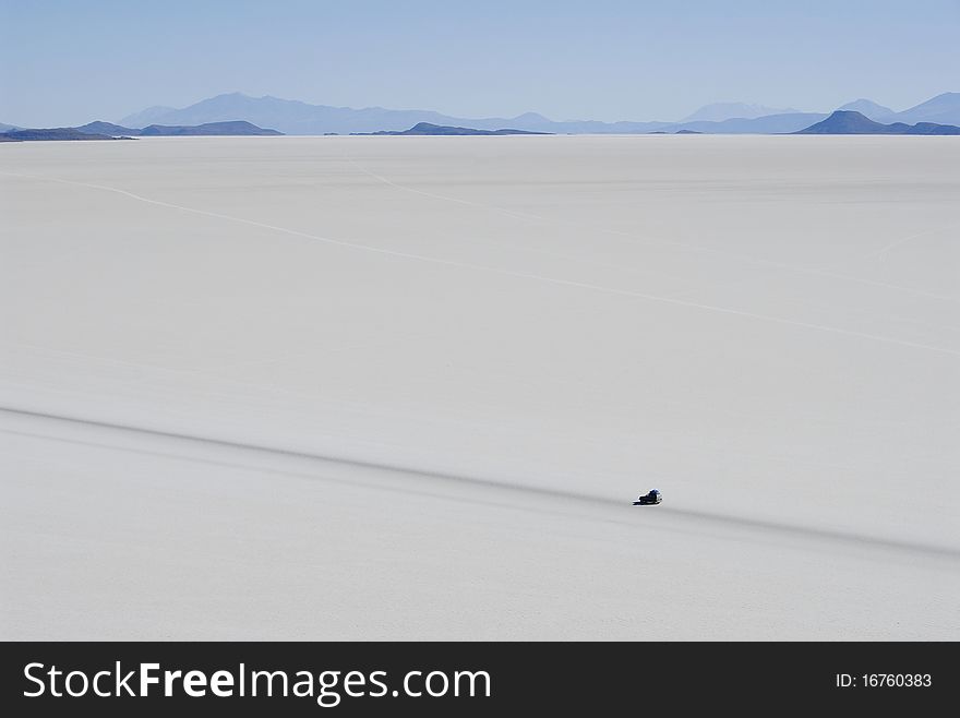 Jeep in Tunupa salt flats, with volcanic hills in the distance