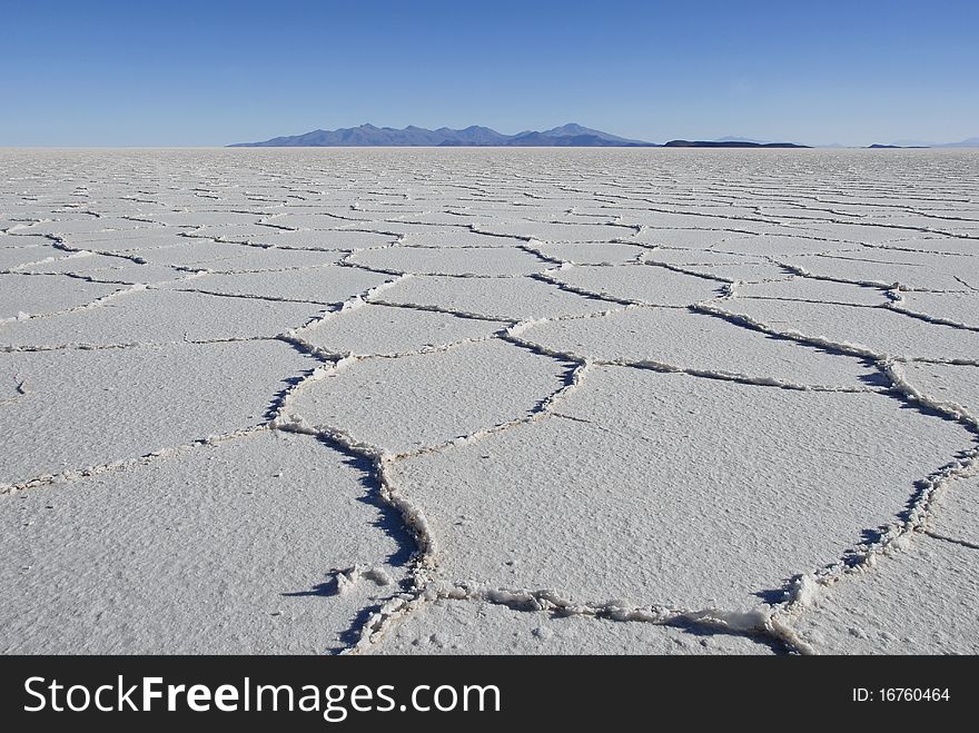 Patterns in the salt of Tunupa salt flats, with volcanic hills in the background