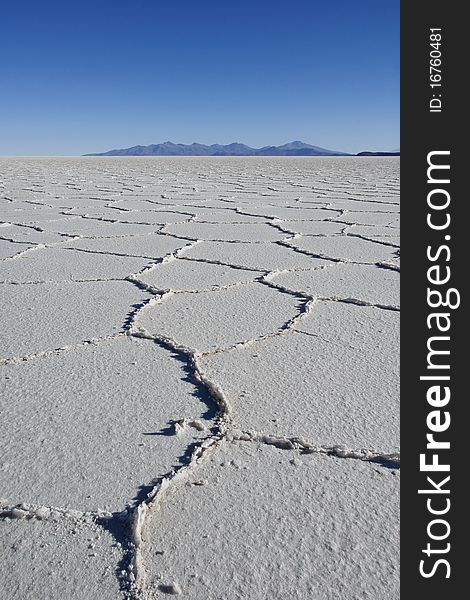 Patterns in the salt of Tunupa salt flats, with volcanic hills in the background