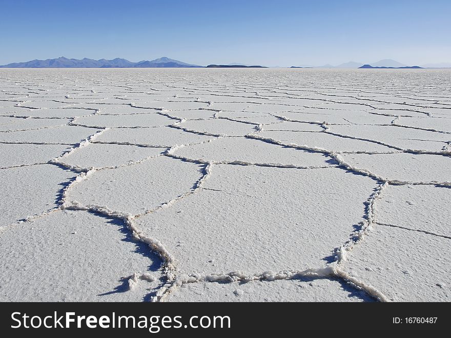 Patterns in the salt of Tunupa salt flats, with volcanic hills in the background