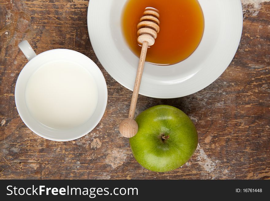 Breakfast with milk, honey and apple on the old wooden table