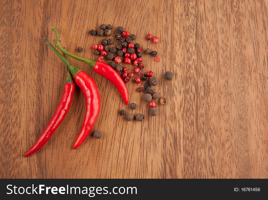 Red chili pepper and pepper's mix on the wooden desk