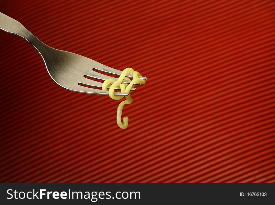 Noodle on a fork against red stripped background. Noodle on a fork against red stripped background