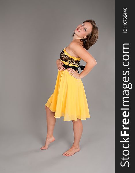 Woman in yellow dress. Gray background