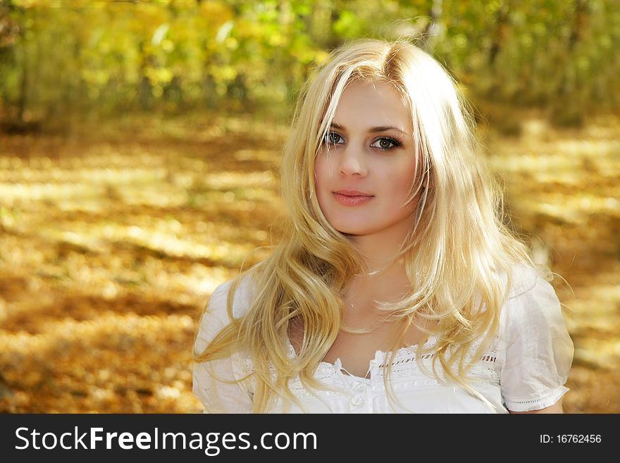 Beautiful young girl on autumn forest background