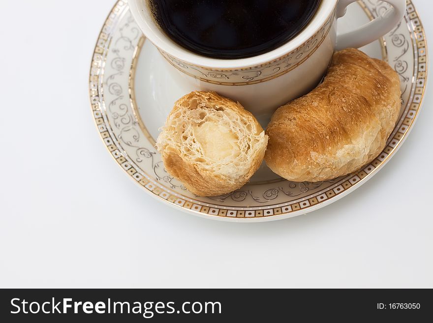 Cup of coffee and croissants on the plate