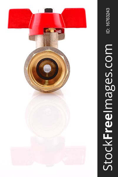 The water valve from a brass with the red handle on a white background
