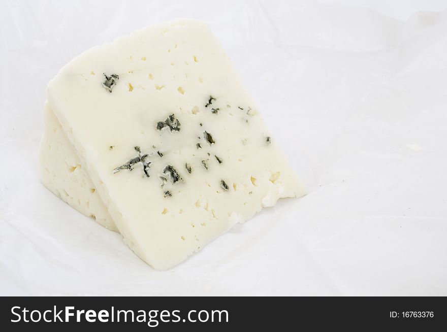 Piece of Roquefort cheese over white