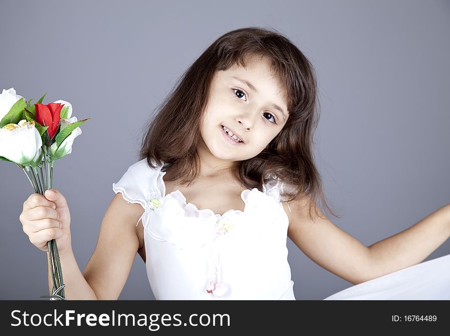 Young girl in dress and flowers. Studio shot.