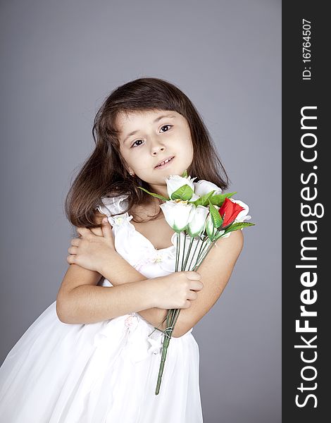 Young girl in dress and flowers. Studio shot.