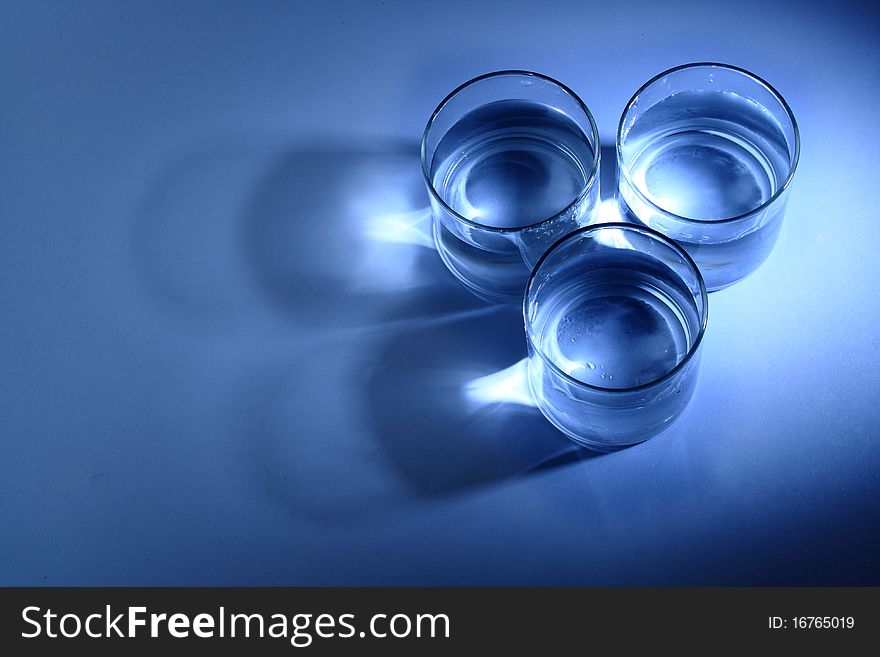 Three glasses of water in a blue background