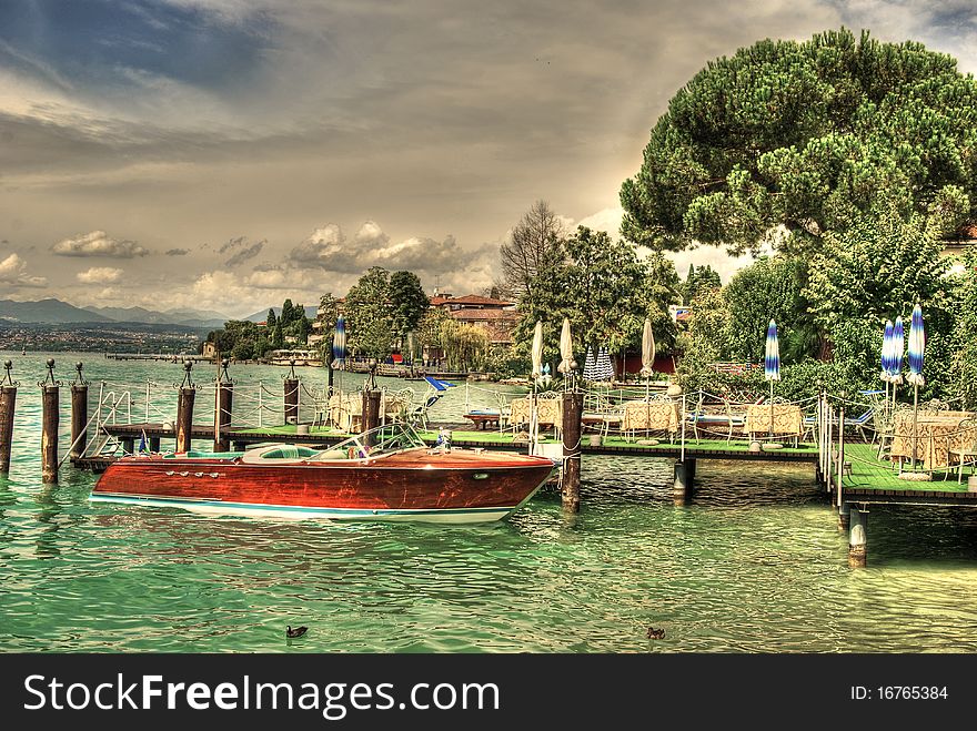 A boat in harbour of the shore of Sirmione Lake Garda Lombardy northern Italy. A boat in harbour of the shore of Sirmione Lake Garda Lombardy northern Italy