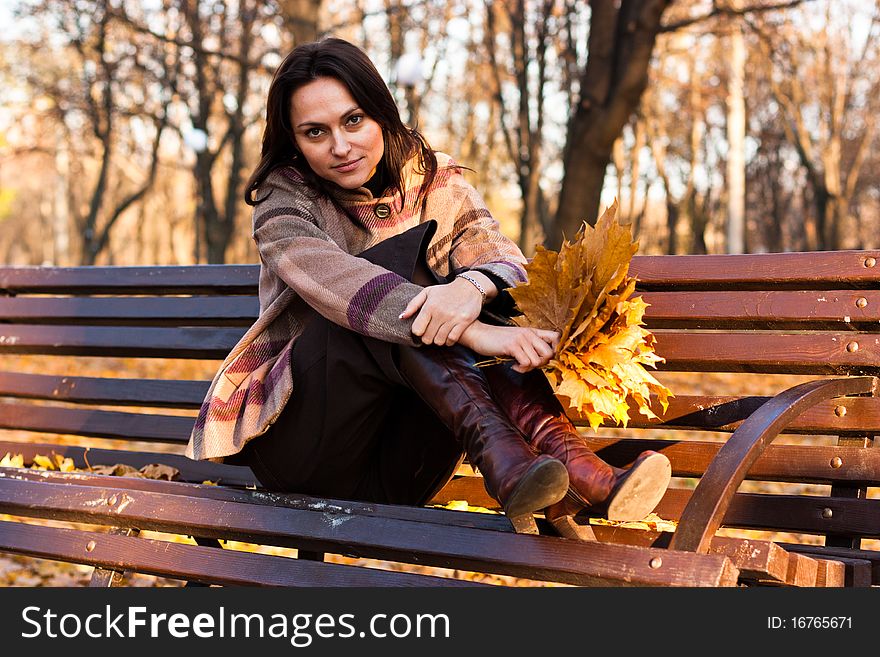 Beautiful young woman on a bench in autumn. Beautiful young woman on a bench in autumn