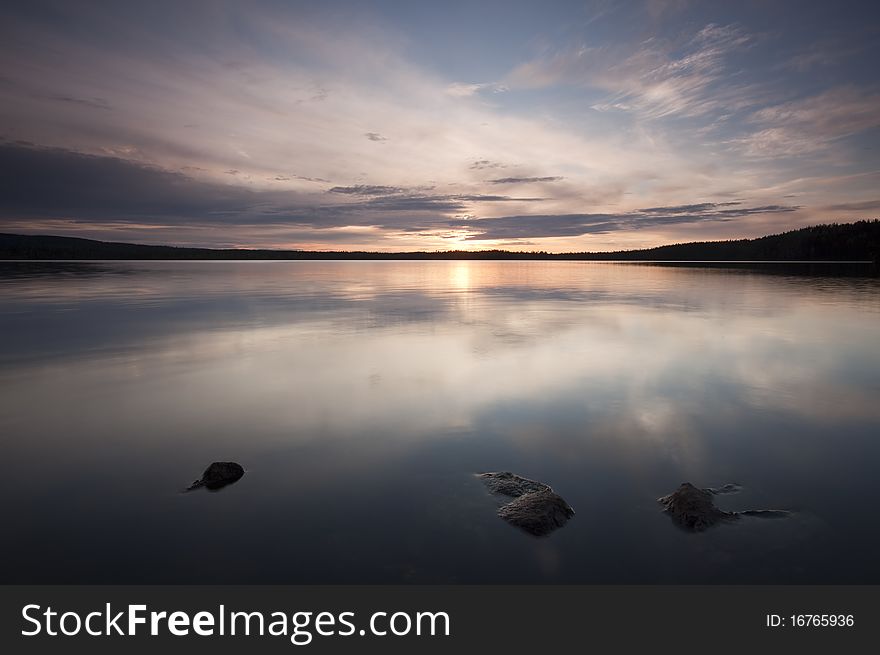 A calm lake. The clouds are reflecting on the surface.