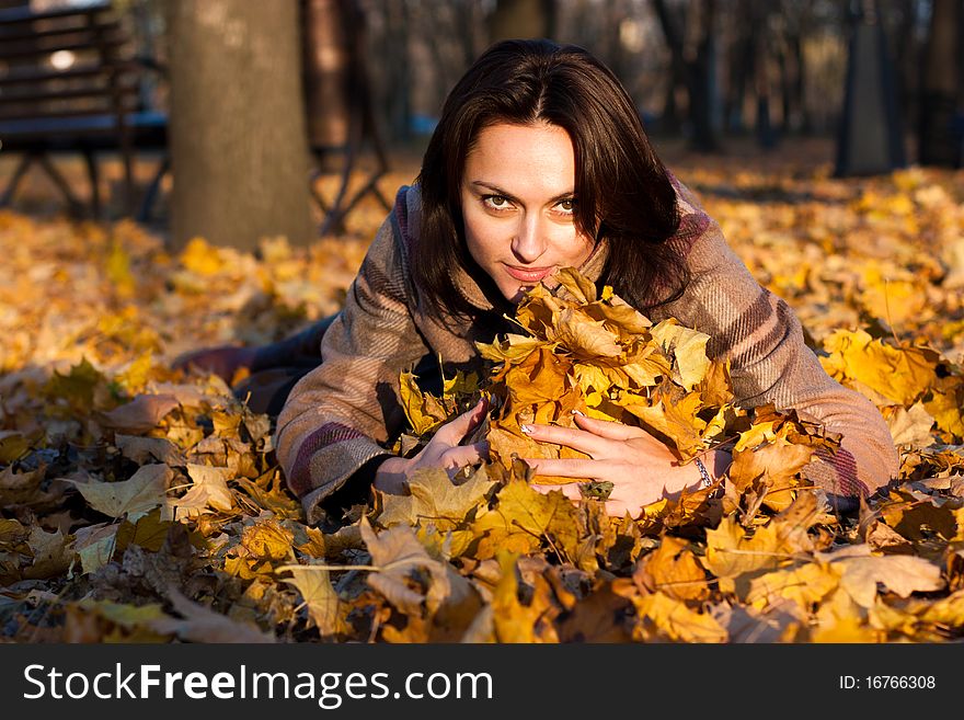 Beautiful Young Woman Lying In Autumn Leaves