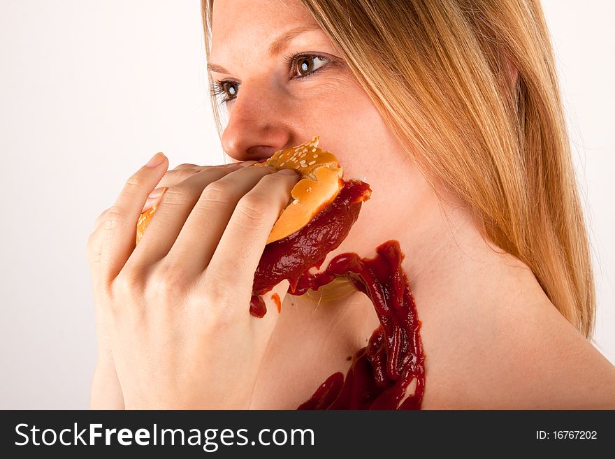 A young woman eating a burger. A young woman eating a burger