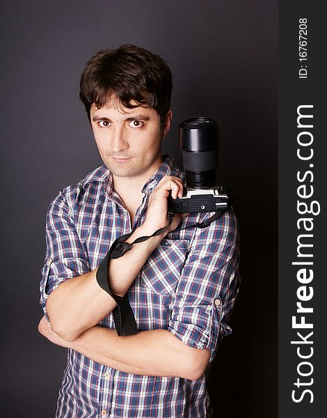 Portrait of young attractive man with camera, studio shot. Portrait of young attractive man with camera, studio shot