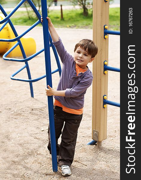 Full-lengh portrait of smiling little boy on adventure playground
