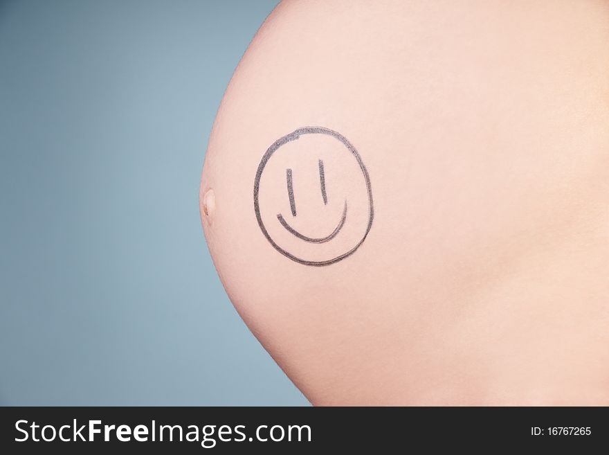 Tummy of pregnant woman with little drawing, studio shot